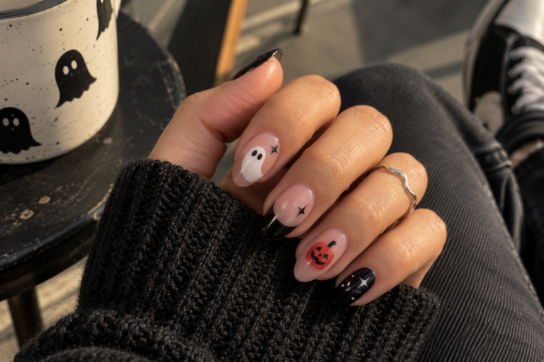 Short nails with ghost, pumpkin and star designs on a sheer nude base